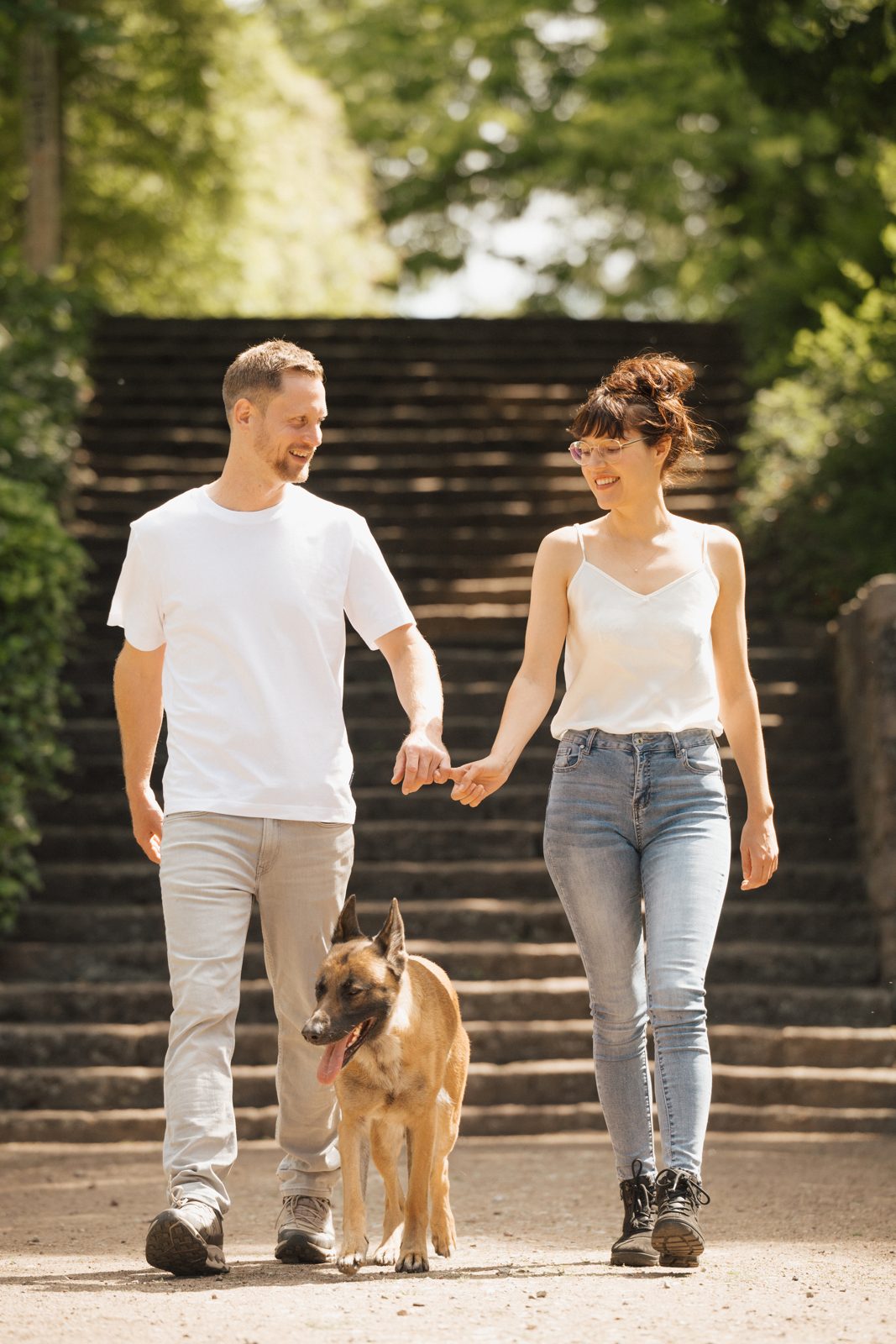 Clemens und Ronja gehen Hand in Hand eine Treppe hinunter, Mali läuft vorneweg