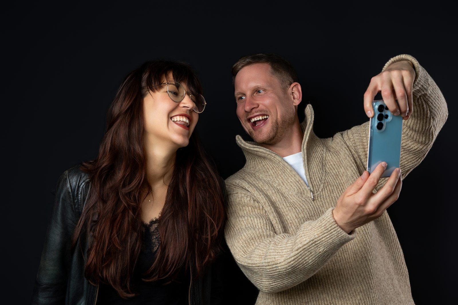 Clemens und Ronja lachen gemeinsam über etwas auf dem Handy